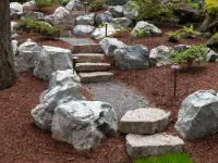 Hillside accented with big rocks and stone stairs.